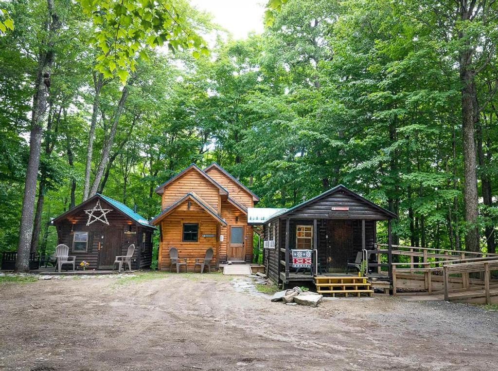 a couple of cabins in the woods at Three Cabins - Pet Friendly & Hot Tub in Warren