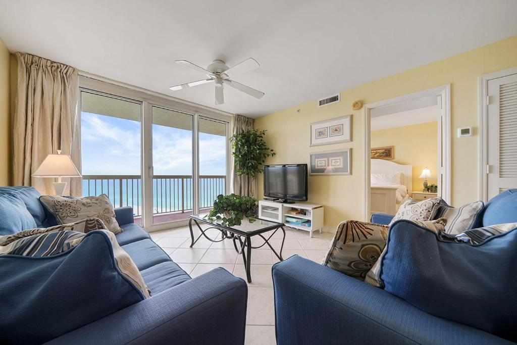 a living room with two blue couches and a television at Pelican Beach 1216 - Ocean Front Condo with Shared Pool & Beach Access in Destin