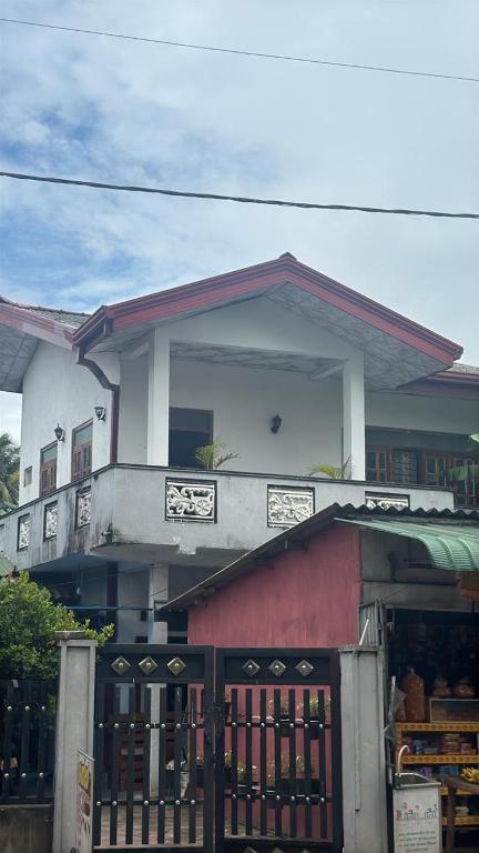 a building with a gate in front of it at Dad's Inn by Wee Group in Andiambalama