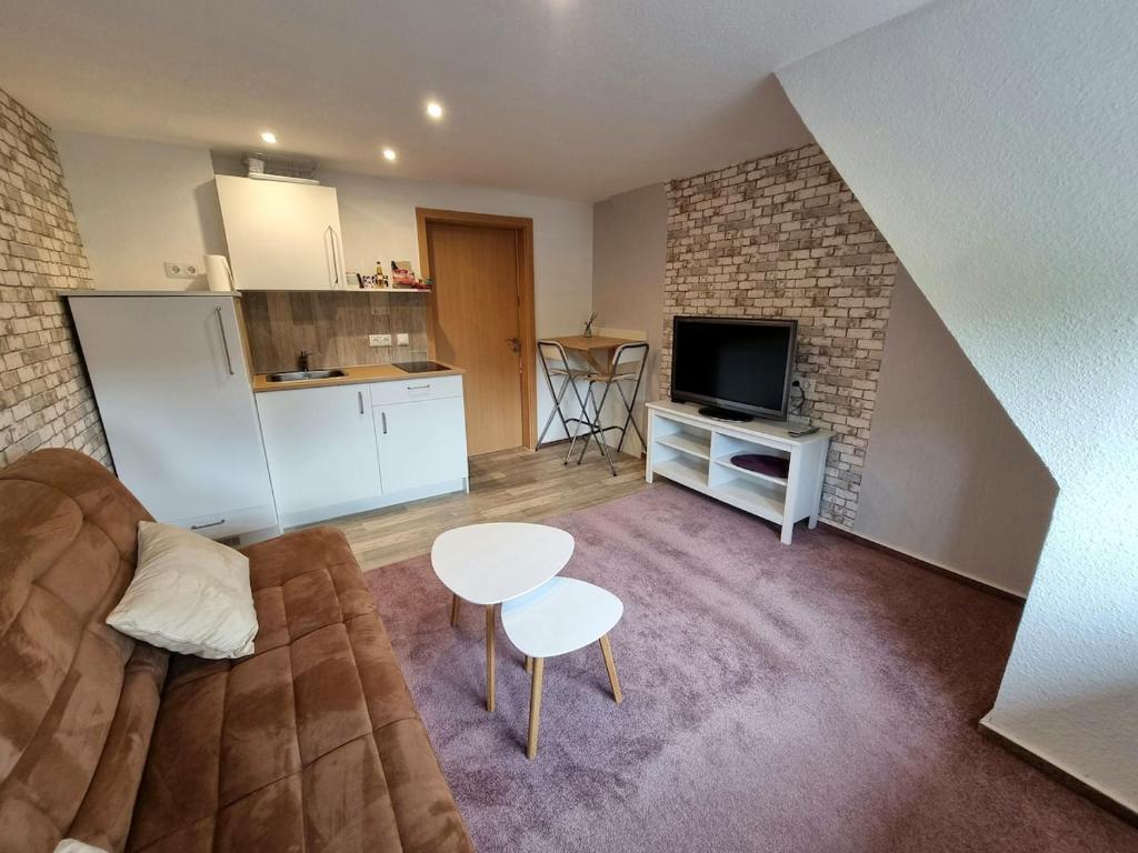 a living room with a couch and a table and a kitchen at Schnuckelchen in Marl 2 in Marl