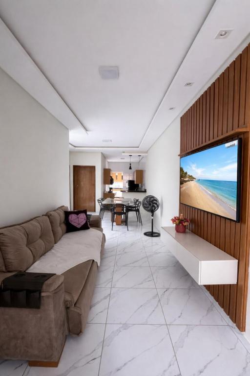 a living room with a couch and a flat screen tv at Casa 3 Quartos Ar Condicionado , Area de Churrasco in Petrolina