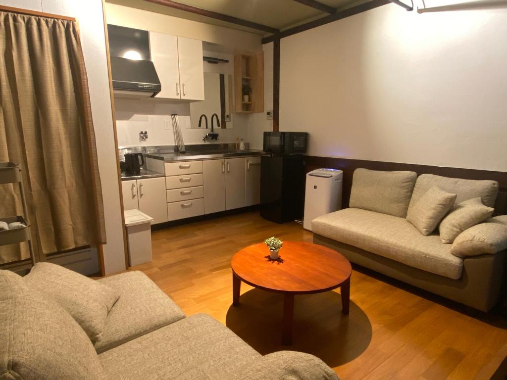 a living room with a couch and a table at 夕食ご用意可能guesthouse Yokomachi 街の中心部 静かな通りの一棟貸切 in Shingū