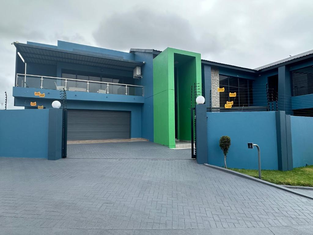 a blue and green house with a garage at Kbros Guesthouse in Polokwane