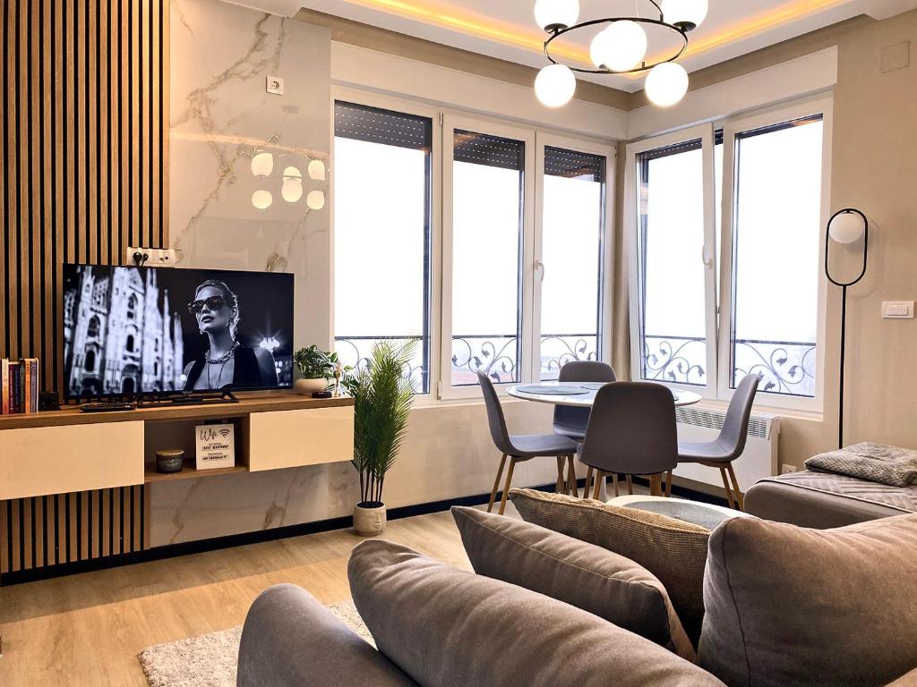 a living room with a tv and a table and chairs at Beli Bregovi Lux in Zlatibor