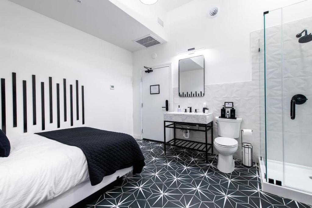 a bedroom with a bed and a sink and a toilet at Hollyhock Suite 409 in Louisville