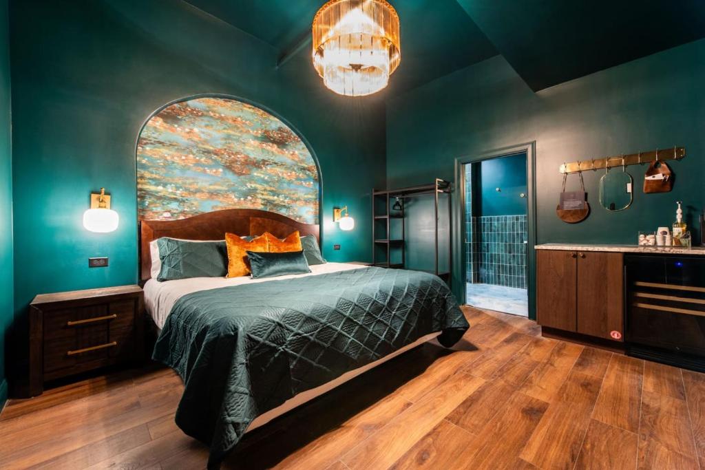 a bedroom with a bed with a large painting on the wall at Hollyhock Suite 411 in Louisville