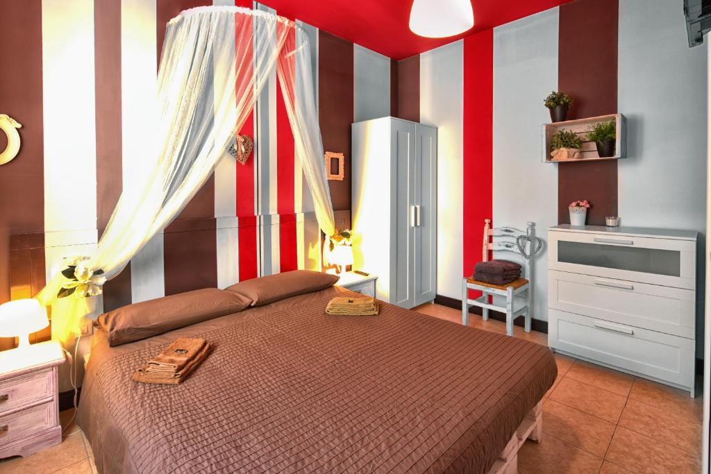 Schlafzimmer mit einem Bett mit roten und weißen Streifen in der Unterkunft La Casa Di Miele in Marcignago