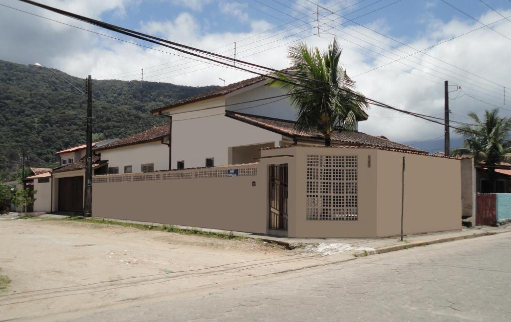 a white house with a palm tree in front of it at Casa Perequê-Açu in Ubatuba