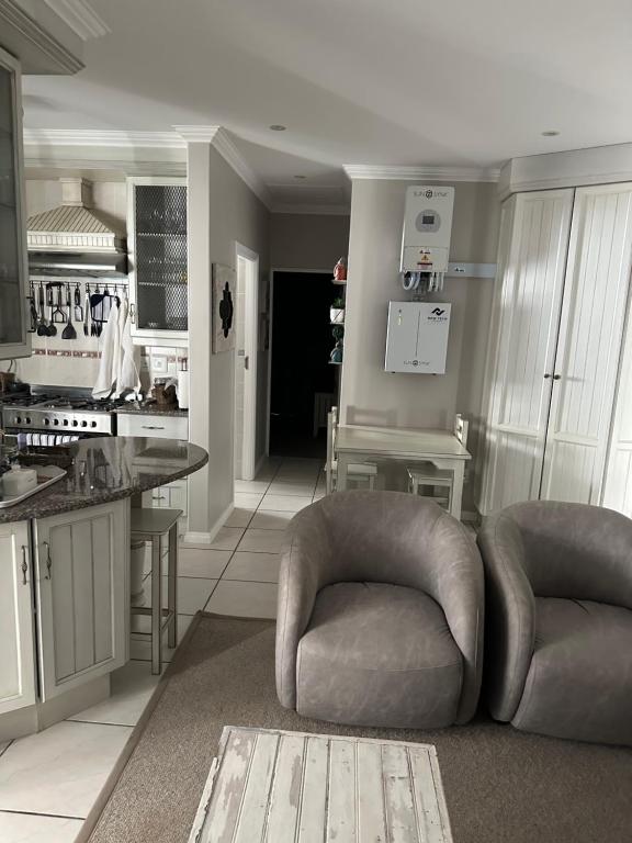 a kitchen with two chairs and a table in it at Sea Breeze in Mossel Bay