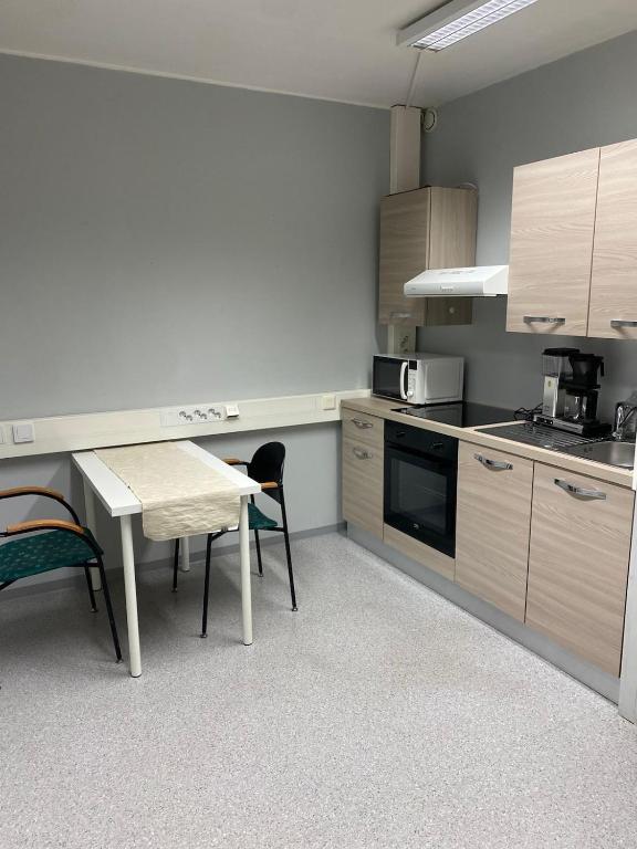 a kitchen with a table and a table and chairs at Varastotie 1C in Ylivieska