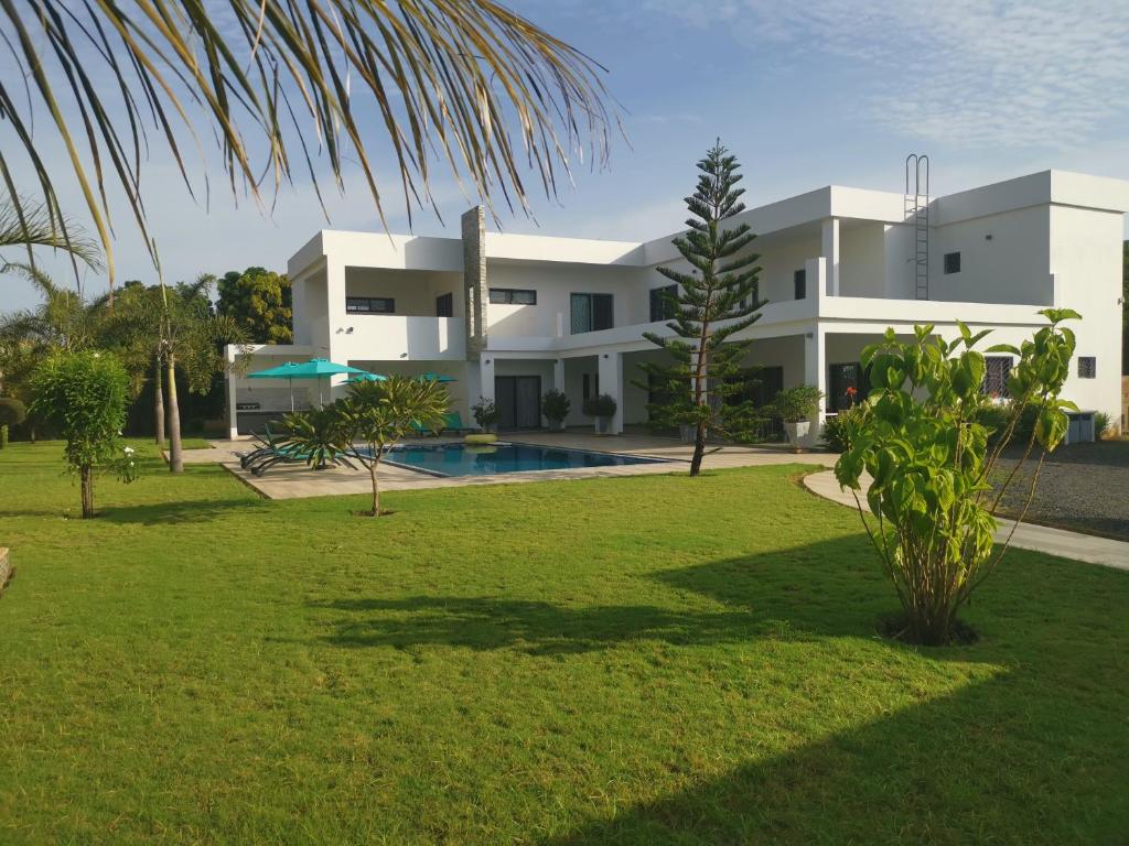 a large white building with a swimming pool in a yard at VILLA Keur Diam in Somone