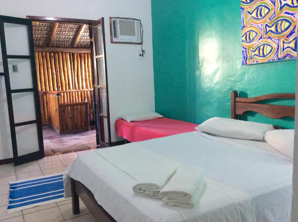 1 dormitorio con 2 camas y puerta a una habitación en Canto do Buganville, en Abraão