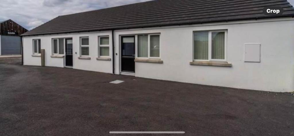 a white building with a lot of windows at Copperbeech Farm Cottages in Maze