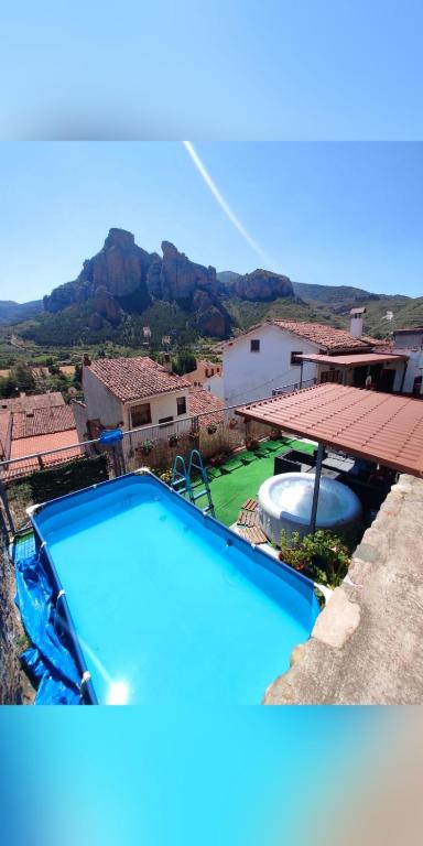 a large blue swimming pool with a mountain in the background at Casa Terzia a 10 min de Logroño in Islallana