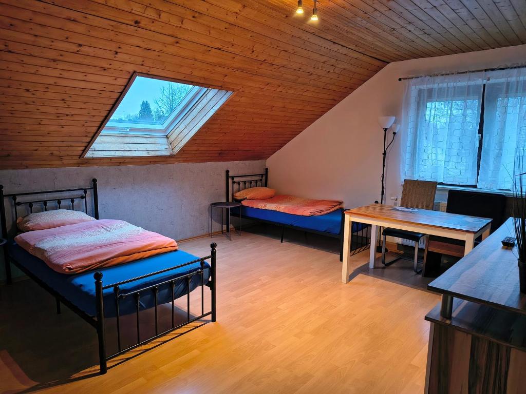 a room with two beds and a table and a window at Hostel Fantasy in Gröbenzell