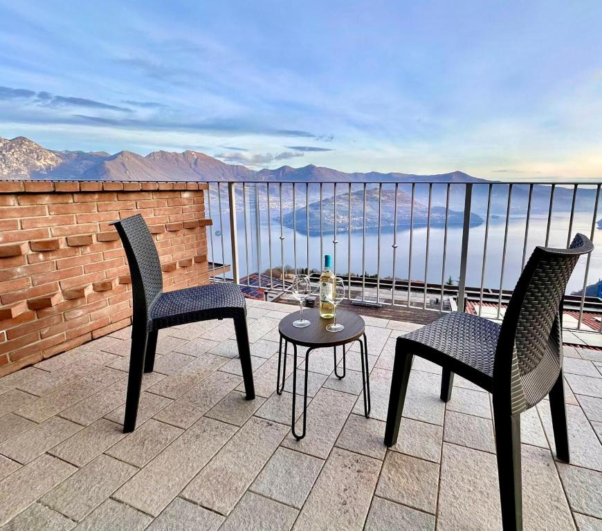 a balcony with two chairs and a table with a bottle of wine at Iseo Panorama Suite in Parzanica