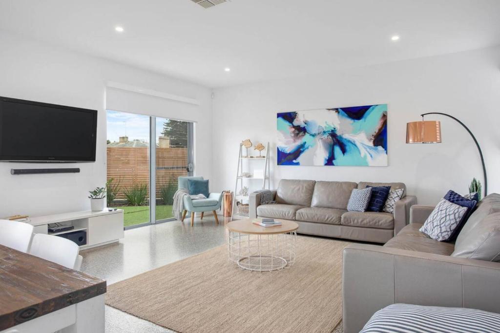 a living room with a couch and a tv at Atlantis - Coastal Retreat near Horseshoe Bay in Port Elliot