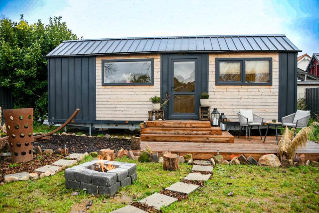 a tiny house in a yard with a fire pit at Seebrise Adria in Altrip