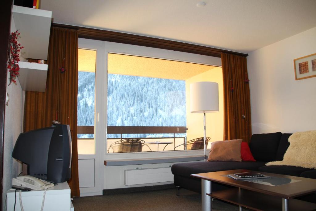 a living room with a couch and a large window at Hotel Europe App 303 in Davos