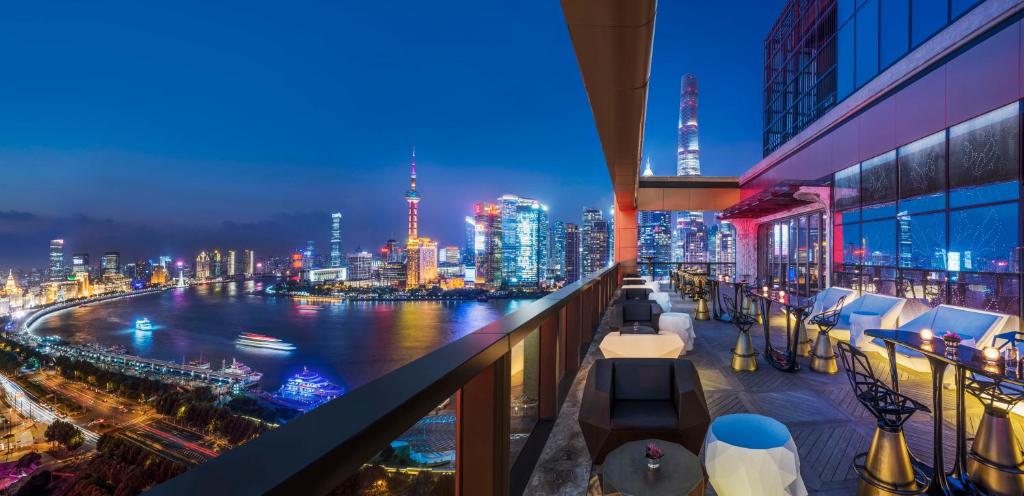 a view of a city skyline at night from a balcony at Wanda Reign on the Bund in Shanghai
