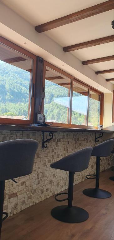 a room with two tables and two windows at Къща за гости ОЗИ 3 in Ovchartsi