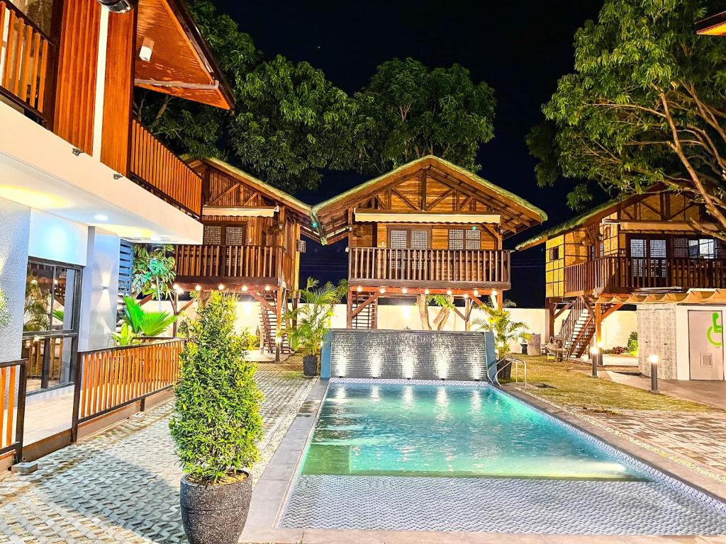 a house with a swimming pool in front of it at Treehouse Executive Villas - ANGELES in Malino