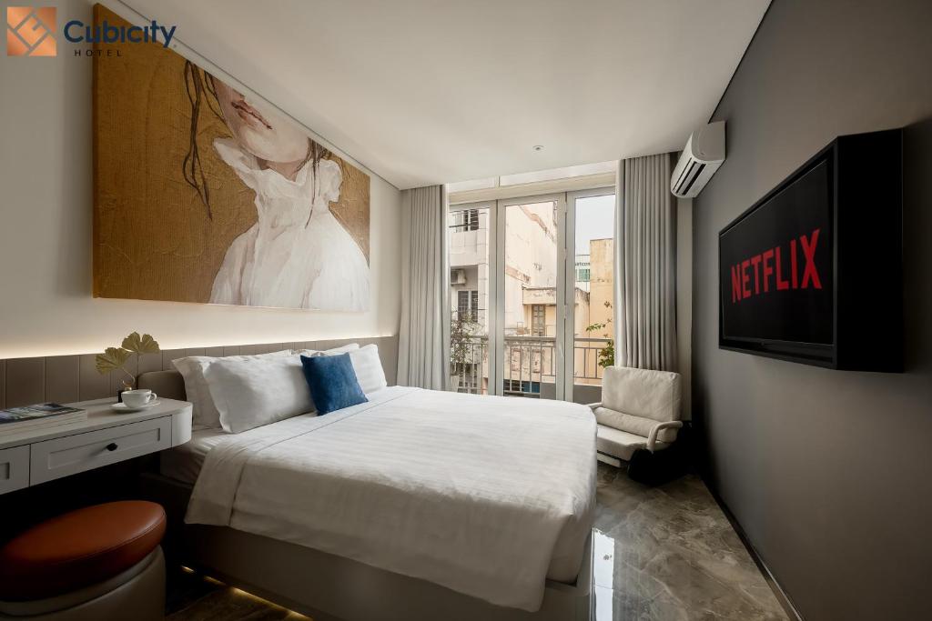 a hotel room with a bed and a television at Cubicity Ton That Tung in Ho Chi Minh City