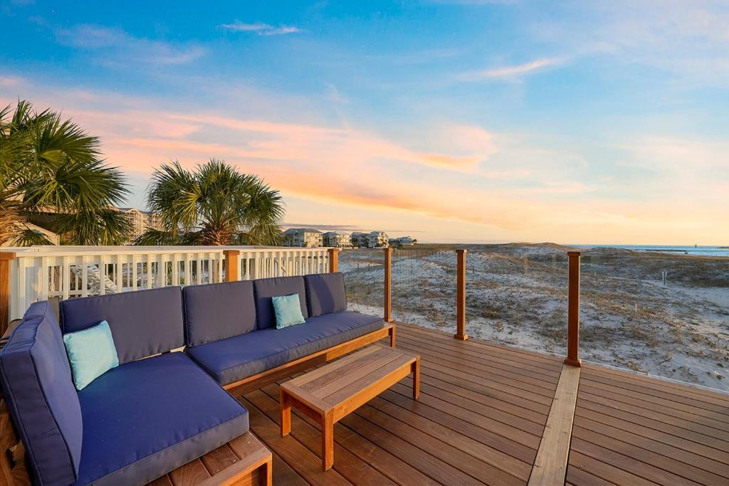 a blue couch sitting on a deck with the beach at Twin Palms - Beachfront Duplex with Ocean Views & Direct Beach Access in Destin