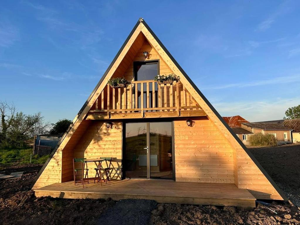 a frame house with a deck and a balcony at Tiny house in Saint-Rémy-Boscrocourt
