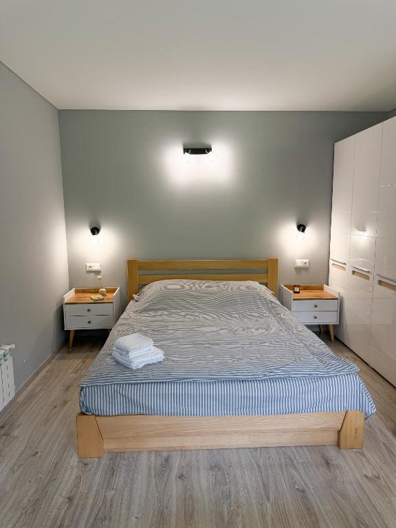 a bedroom with a large bed and two night stands at Hygge Apartment in Mizhhirya