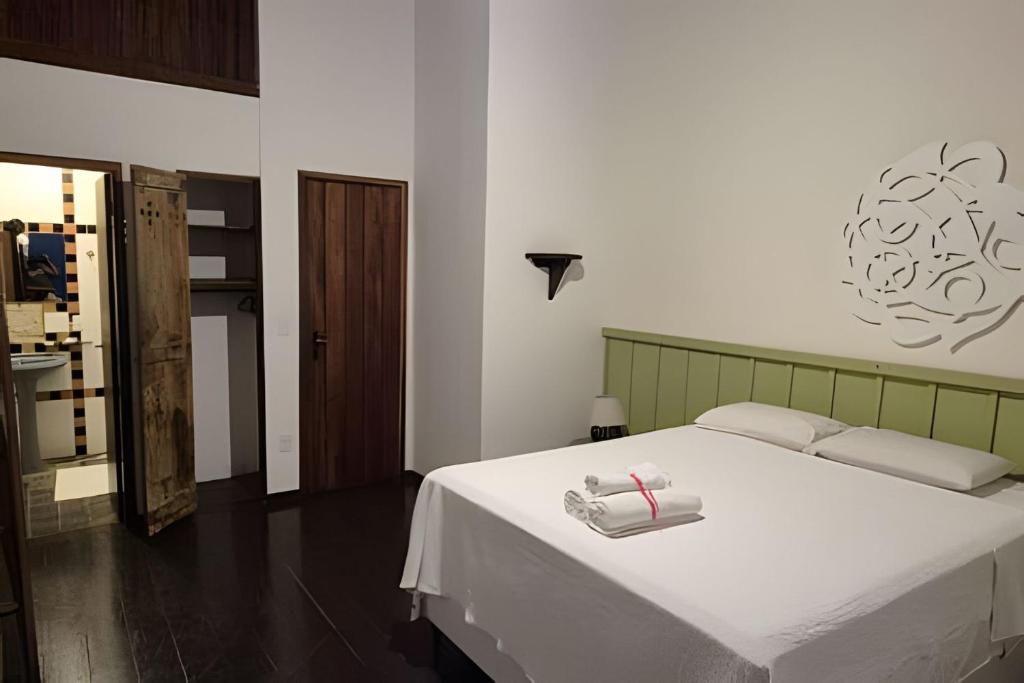 a bedroom with a bed with two towels on it at Solar Itacaré - Charme e aconchego. in Itacaré