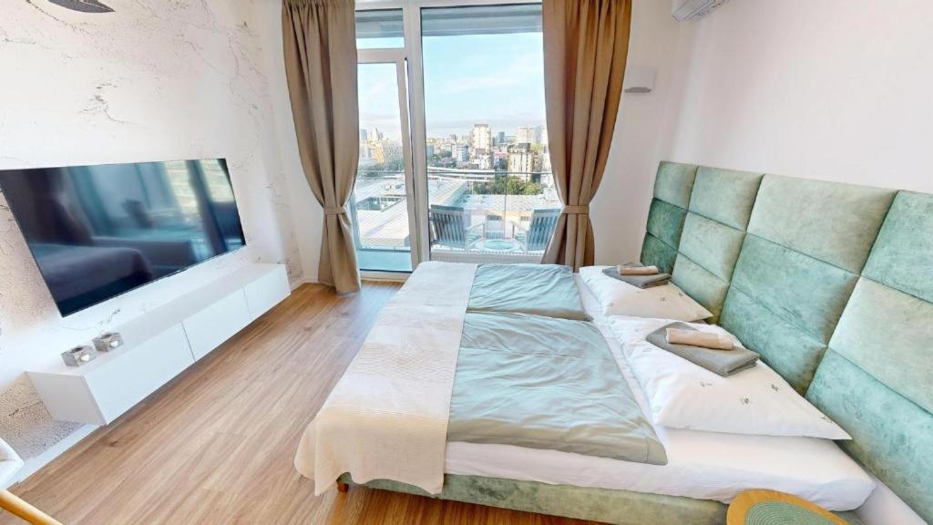 a bedroom with a large bed and a large window at Apartment FreshOlive in Trnávka