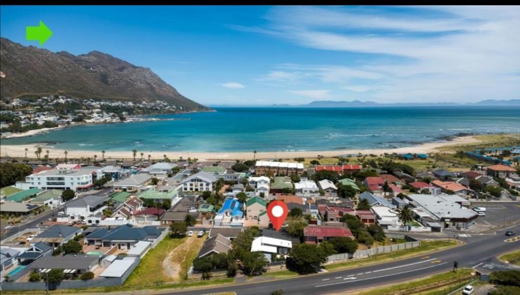 an aerial view of a small town next to the ocean at Beach House Living in Gordonʼs Bay