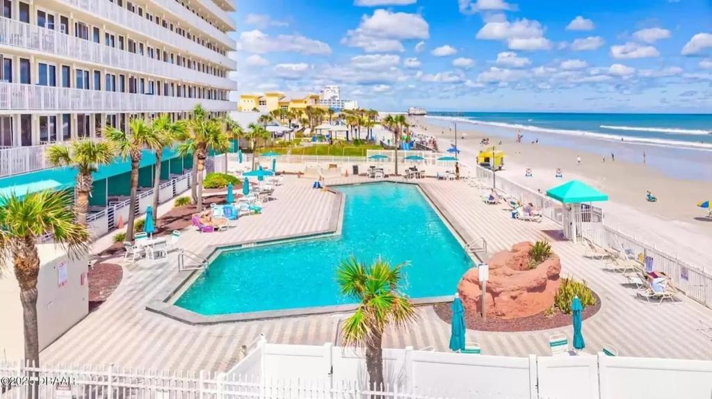 a view of the pool and beach at the resort at Beach Front Resort with Ocean View in Daytona Beach