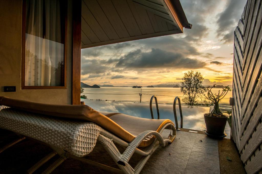 - une terrasse couverte avec une chaise et une vue sur l'eau dans l'établissement Koh Yao Yai Hillside Resort, à Ko Yao Yai