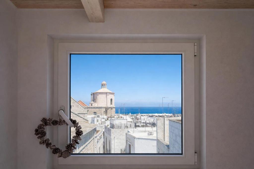 a window with a view of a city at Hotiday Polignano Centro - Fico d'India in Polignano a Mare