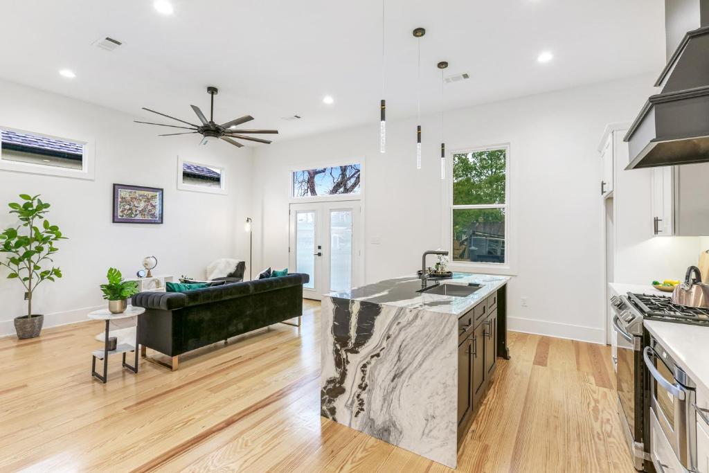 an open kitchen and living room with a couch at The Royal Haus NOLA 3 Bed Beauty in New Orleans