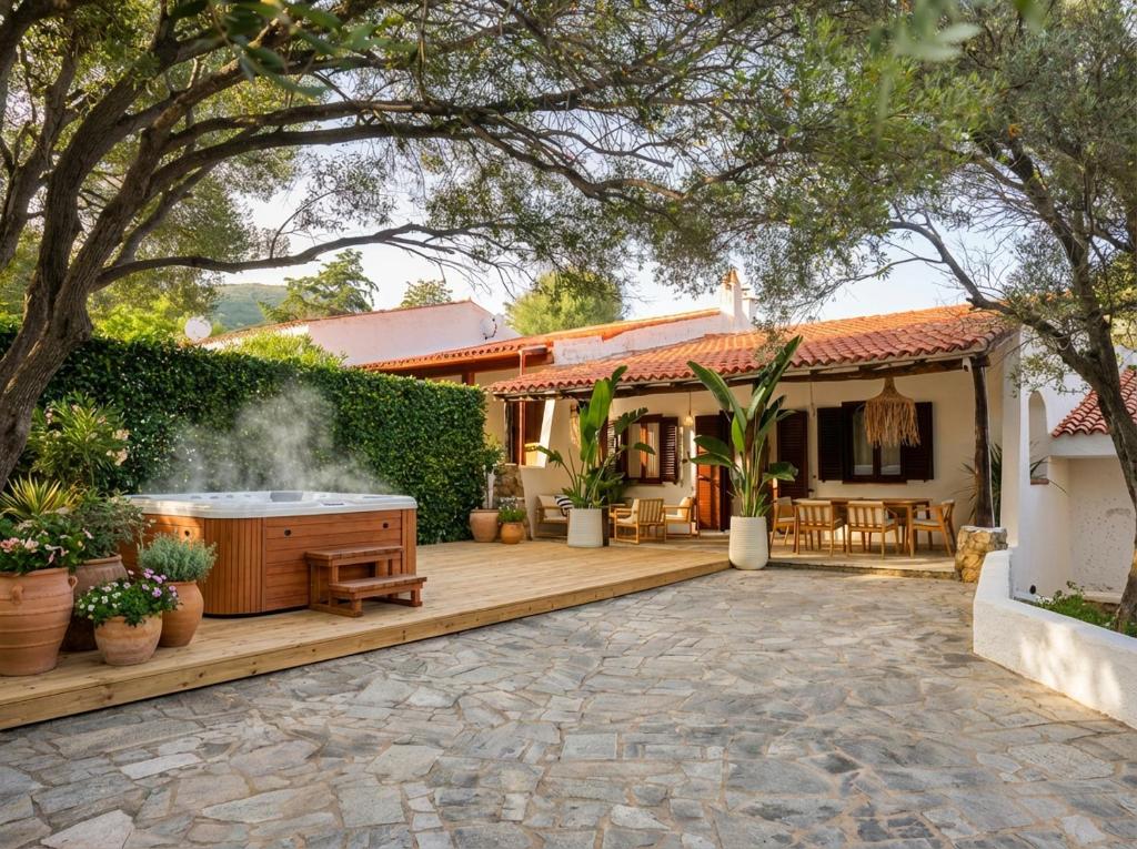 a backyard with a hot tub and a house at Villa Maison Rosabianca - Costa Smeralda by Rosabianca Collection in Cugnana Verde