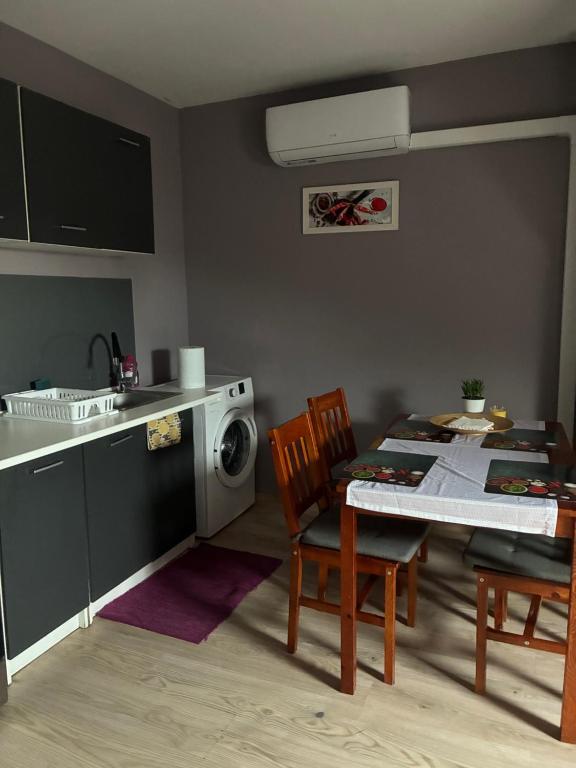 eine Küche mit einem Tisch und einer Waschmaschine in der Unterkunft Łowicka22 in Piątek