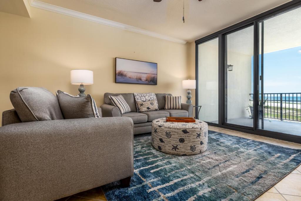 a living room with a couch and a table at Wave Watcher - Holiday Isle #609 in Dauphin Island