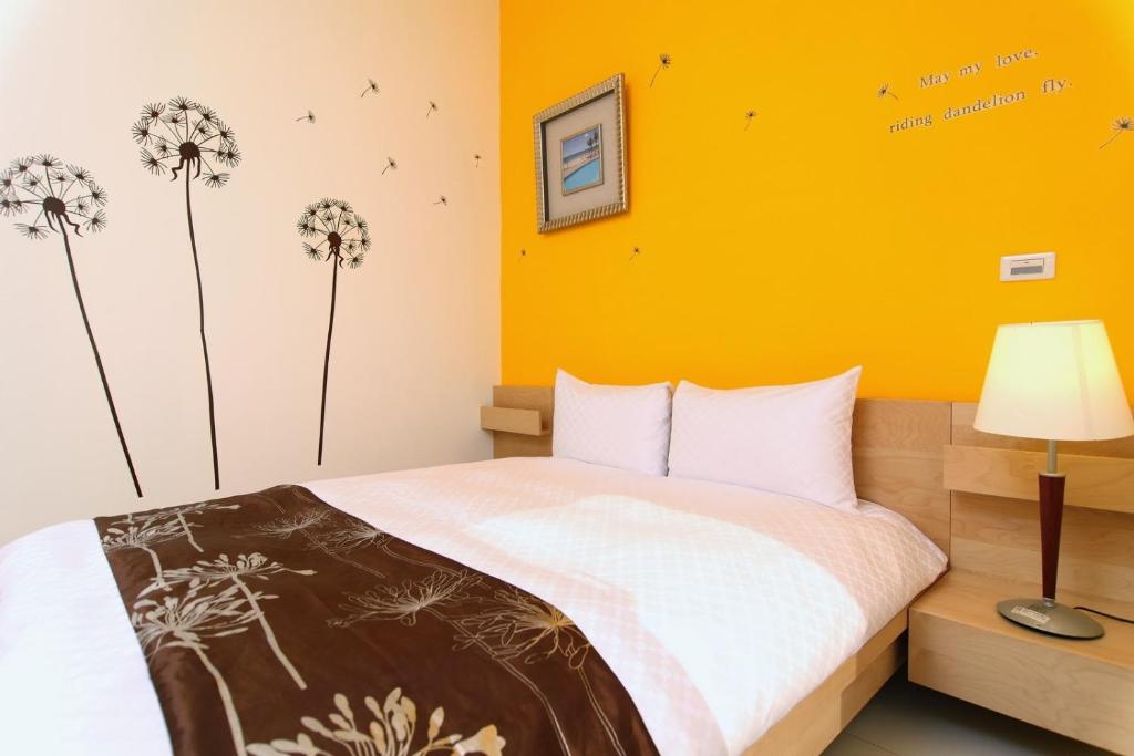 a bedroom with a bed with dandelions on the wall at Plentiful-Inn Kenting in Hengchun South Gate