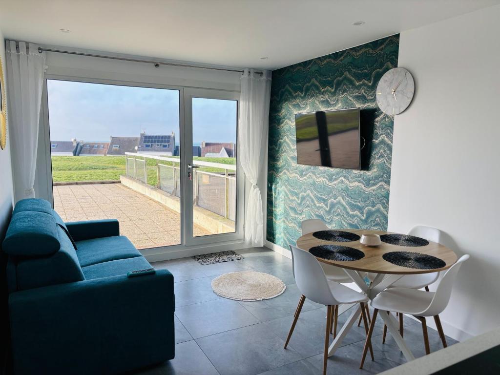 salon z niebieską kanapą i stołem w obiekcie sunset lodge calais w Calais