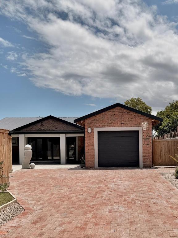 a brick house with a garage in a driveway at 10 on Sysie in Sedgefield