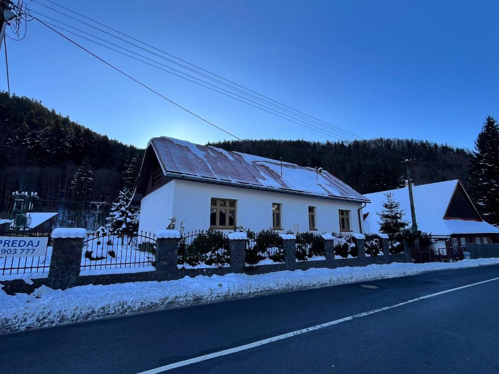 a white house with a fence on the side of the road at Vila Dom pod Chopkom in Bystrá
