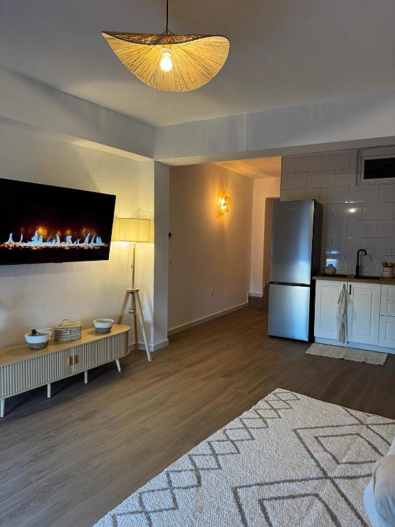 a living room with a fireplace and a refrigerator at Las eras 84 in Níjar