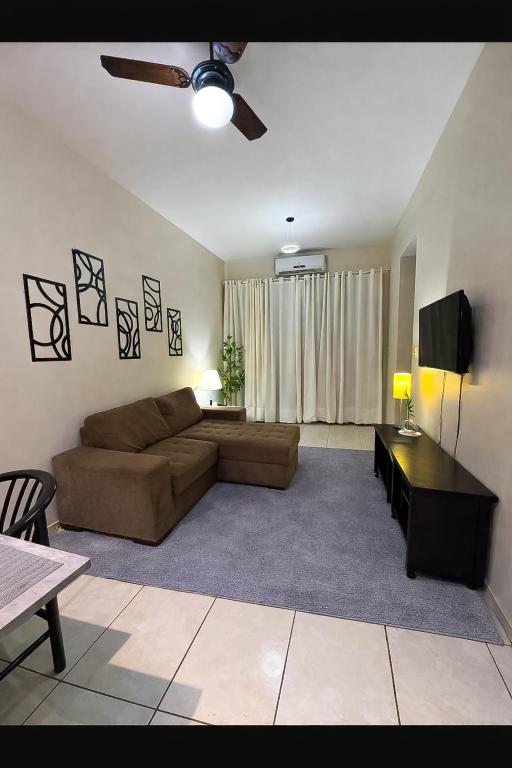 a living room with a couch and a tv at Flat central com estacionamento in Ribeirão Preto