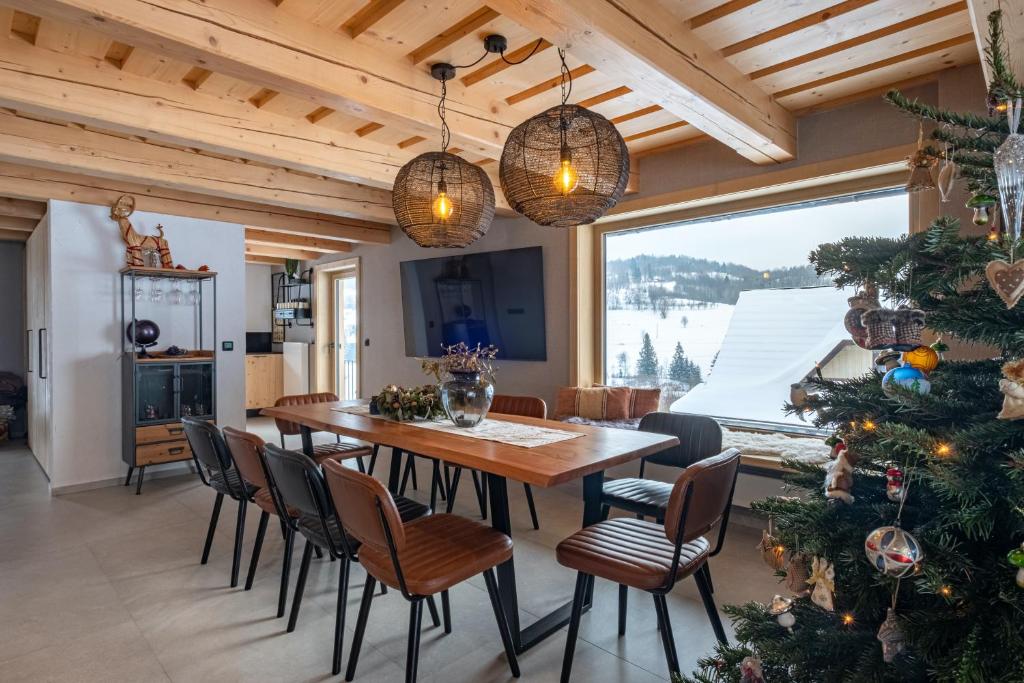 a dining room with a table and a christmas tree at Chata Jarabina in Terchová