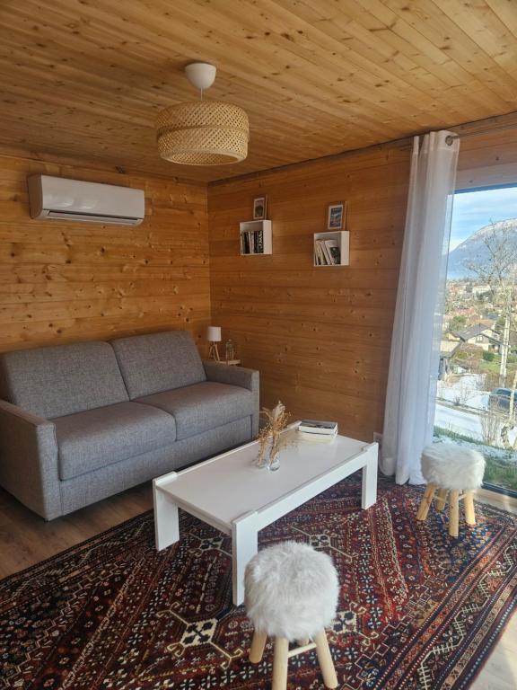 a living room with a couch and a table at Le Petit Chalet in Saint-Jorioz