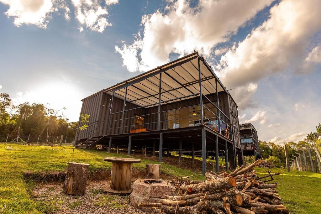 a large black house with a dog sitting in the front of it at Villa Container in the Wine Route in São Roque
