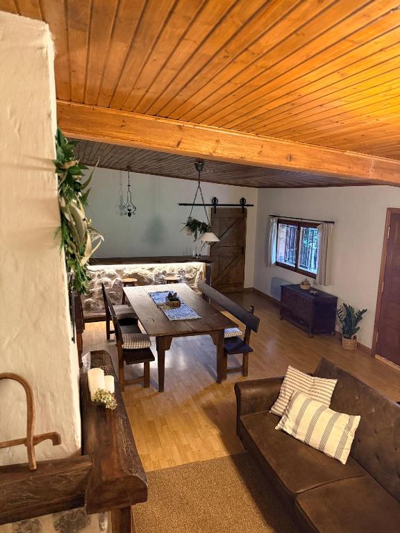 a living room with a wooden ceiling and a table at O Caliu das Airas in León